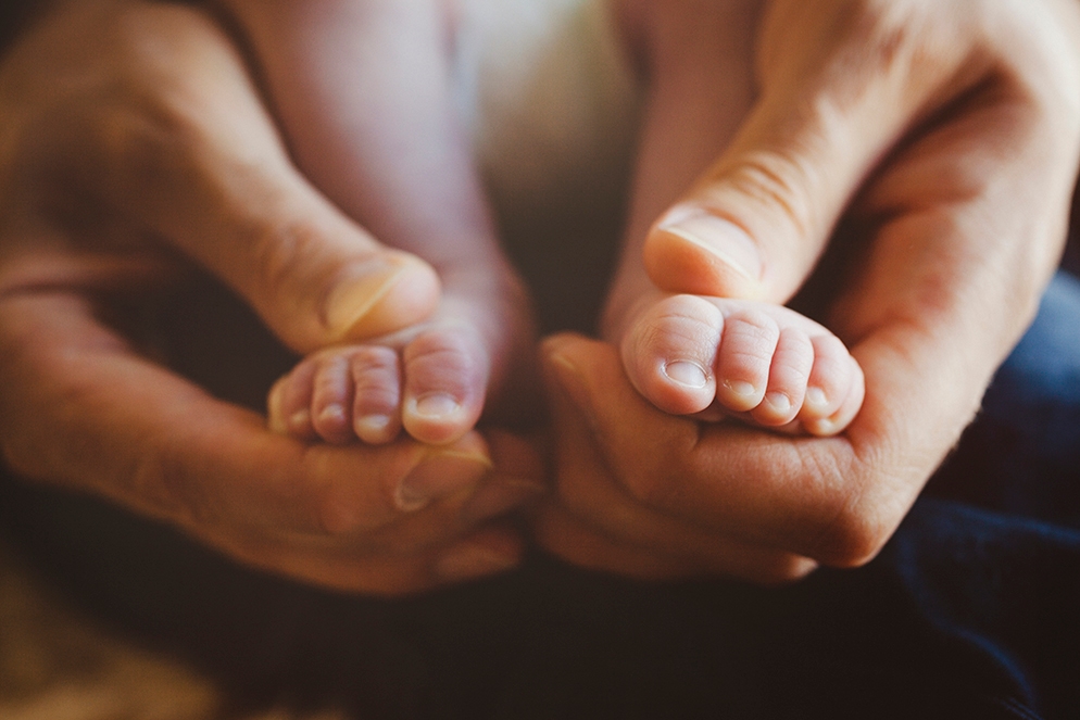 Parent holding baby's feet