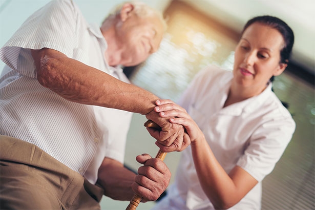 stock photo of nurse helping a patient stand up