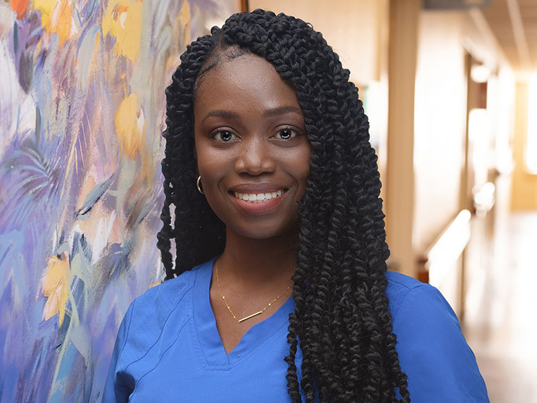 Young woman in nursing uniform in hospital hallway