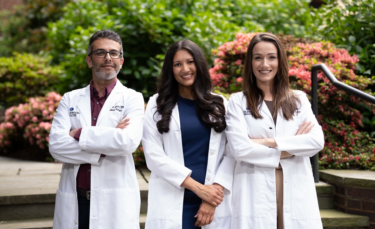 three podiatry residents smiling at the camera